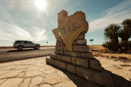 A,Car,Speeds,Along,Past,The,Texas,Border,Sign,From