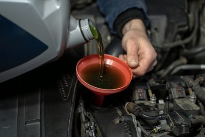 Engine,Oil,Pouring,From,Plastic,Container,Into,Funnel,,Closeup,Of